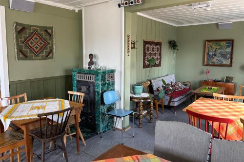 a living room with a fireplace and tables and chairs at Voi Voi Bed & Breakfast in Røros