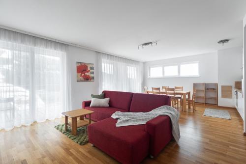 a living room with a red couch and a table at Lux 11 in Sonnenalpe Nassfeld