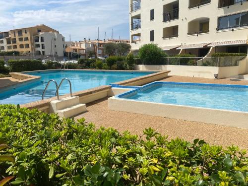 une piscine au milieu d'un immeuble dans l'établissement Appartement spacieux 8 couchages, au Cap d'Agde