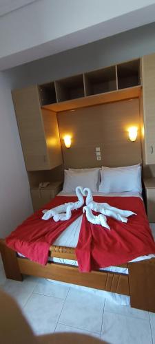 a bedroom with a large bed with a red blanket at ΣΕΡΙΦΟΣ ΜΠΙΤς in Livadion