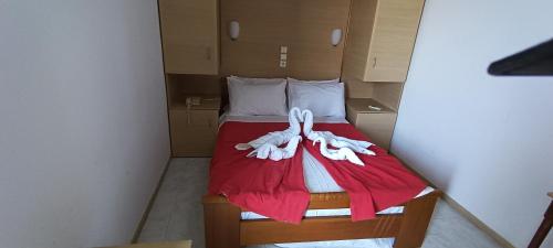 a small bedroom with a bed with a red blanket at ΣΕΡΙΦΟΣ ΜΠΙΤς in Livadion