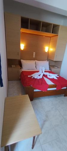 a bedroom with a large bed with a red blanket at ΣΕΡΙΦΟΣ ΜΠΙΤς in Livadion