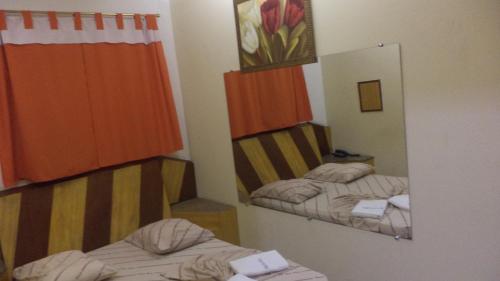 um espelho num pequeno quarto com duas camas em Hotel New Plaza em São Bernardo do Campo