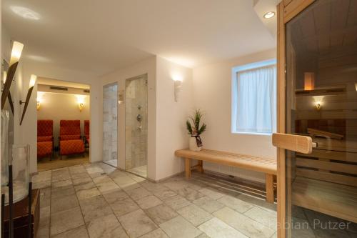 a bathroom with a wooden bench and a window at Ciasa La Rô in San Cassiano