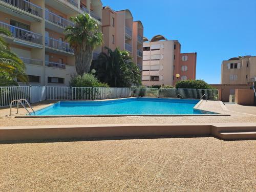 - une piscine en face d'un immeuble dans l'établissement Plage du grazel le thalassa, à Gruissan