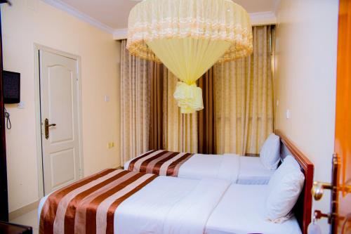a hotel room with a bed and a chandelier at Ineza Hotel Musanze - Snow Hotel in Ruhengeri
