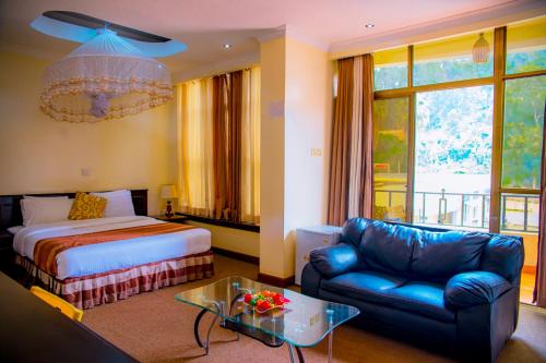 a hotel room with a bed and a couch at Ineza Hotel Musanze - Snow Hotel in Ruhengeri