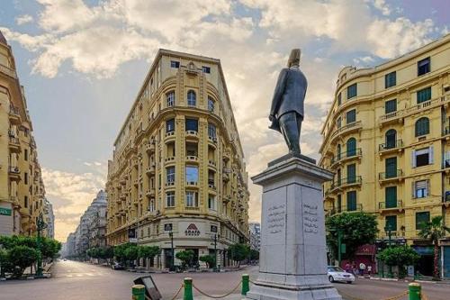una estatua en medio de una ciudad con edificios en New palace court, en El Cairo