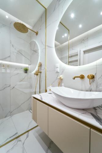 a white bathroom with a sink and a mirror at Polanica Park -LAGUNA - PREMIUM 2 in Polanica-Zdrój