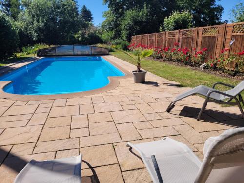 a swimming pool in a yard with chairs and a fence at Stilvolle Fewo Vogelnest, barrierefrei, Smart-TV, Parkplatz in Flöha