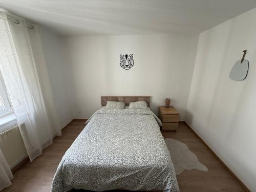 - une chambre blanche avec un lit et une horloge murale dans l'établissement Chambre chez l'habitant - Longwy bas, à Longwy