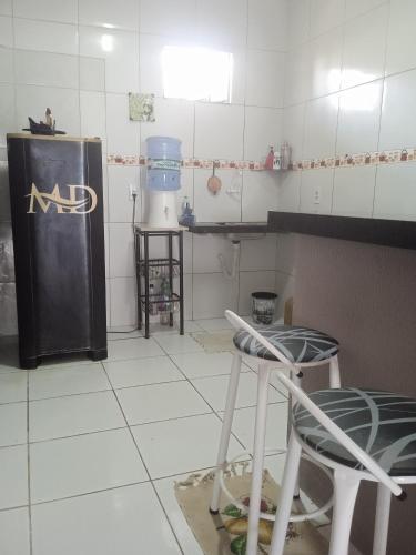 a kitchen with a refrigerator and two stools in it at Casa MD in Camocim