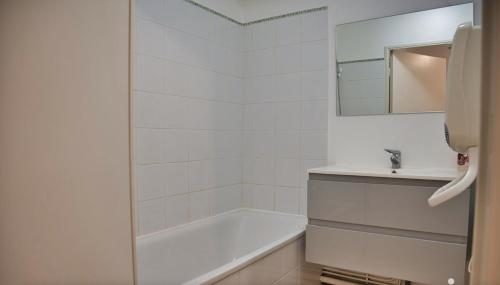 une salle de bain blanche avec une baignoire et un lavabo dans l'établissement près Avignon clim parking jardin, aux Angles (Gard)