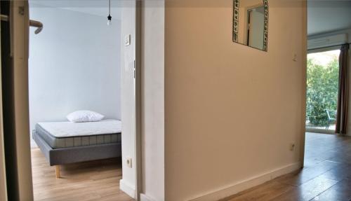 une chambre avec un lit et un miroir au mur dans l'établissement près Avignon clim parking jardin, aux Angles (Gard)