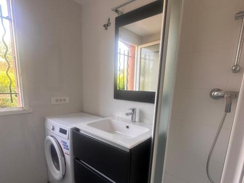 une salle de bain avec un lavabo et une machine à laver dans l'établissement Falea by POM, Terasse, au Cap d'Agde