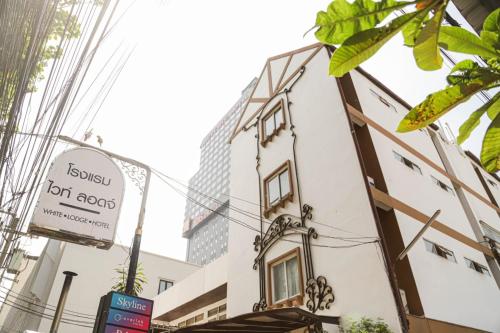 a building with a sign on the side of it at White Lodge Hotel Bangkok in Bangkok