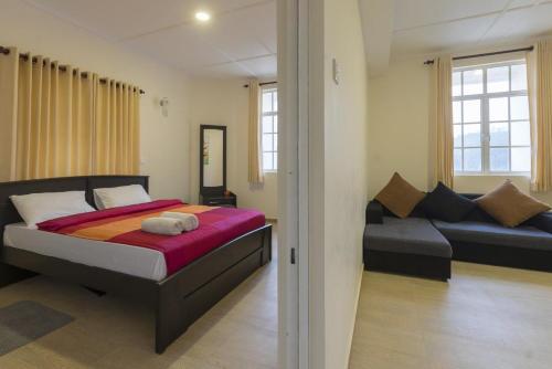 a bedroom with a bed and a couch at Hide Out Hills Bungalow in Nuwara Eliya