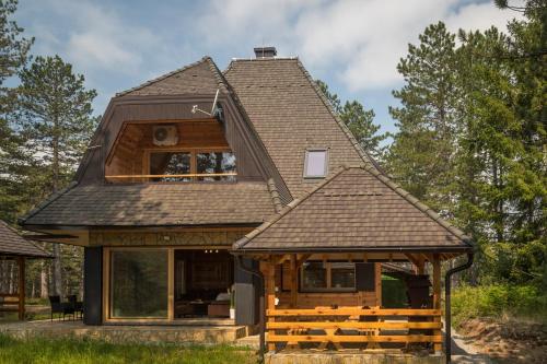 a house with a gambrel roof at Apartman Crni bor 2 Tara in Kaludjerske Bare
