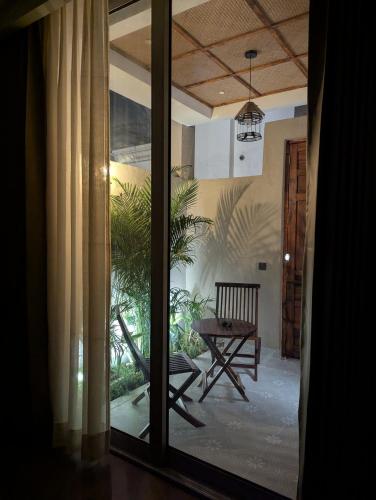 a room with a sliding glass door with a chair and a table at Cape House in Amritsar