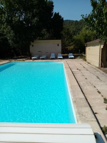 - une piscine d'eau bleue et des chaises longues dans l'établissement Appartement éco-responsable avec piscine, à Châteaudouble