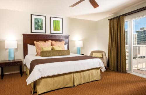 a bedroom with a large bed and a window at Wyndham Waikiki Beach Walk 2BR Apartment with Resort Access in Honolulu
