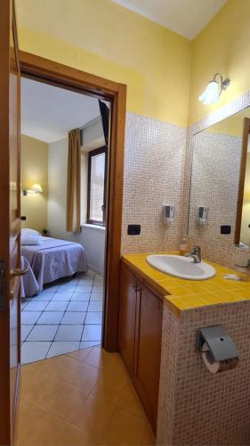 a bathroom with a sink and a bed in a room at Sun Tower beach apartments in Mazara del Vallo