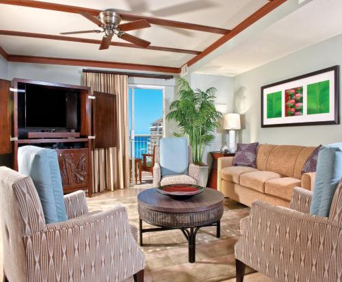 a living room with a couch and chairs and a tv at Wyndham Waikiki Beach Walk 2BR Apartment with Resort Access in Honolulu