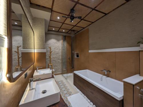 a bathroom with two sinks and a bath tub at Cape House in Amritsar