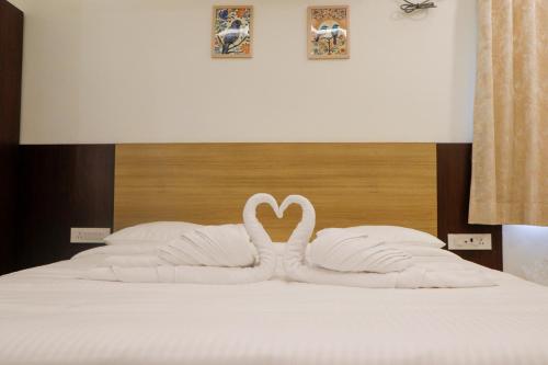 due cigni bianchi che formano una forma di cuore su un letto di Luxury Villa Stays a Tirupati