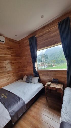 ein Schlafzimmer mit zwei Betten und einem großen Fenster in der Unterkunft Miêu Vương Homestay Mèo Vạc in Mèo Vạc