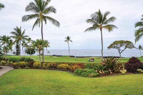 a view of a golf course with palm trees and the ocean at Wyndham Kona Coast Resort 2BR Apartment with Resort Access in Kailua-Kona