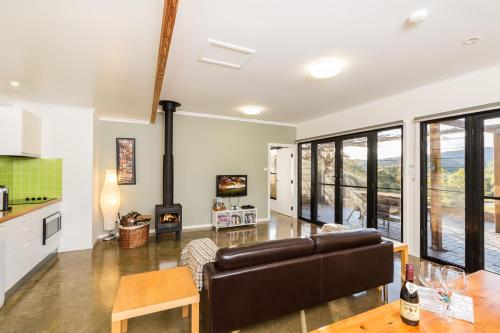 a living room with a couch and a table at Goosewing Cottage in Mount View