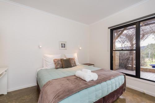 um quarto com uma cama grande e uma janela em Goosewing Cottage em Mount View