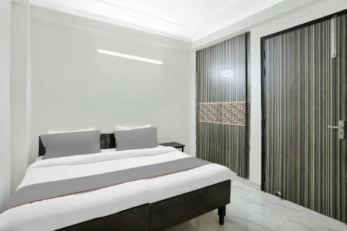 a white bedroom with a large bed and a closet at Live on DEL2479 in New Delhi