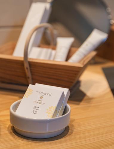 a small bowl with a card in it next to a box at Hôtel Le Bois Joli in Cauterets
