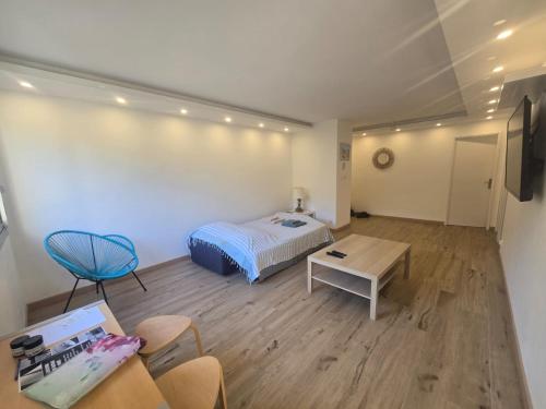 une chambre avec un lit, une table et des chaises dans l'établissement luxueux appart moderne et spacieux, parking plage, à Carry-le-Rouet