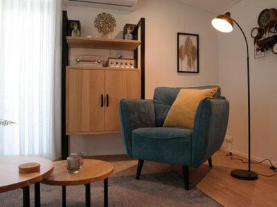 a living room with a blue chair and a table at Bospark chalet 6p in Hardenberg