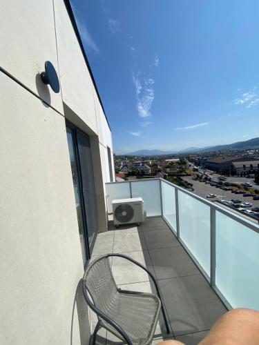 a chair sitting on the balcony of a building at Home Away Bistrița in Bistriţa