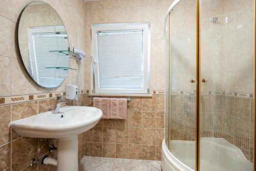 a bathroom with a sink and a shower and a mirror at Apartmani Bonaca Neum in Neum