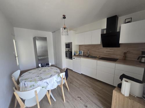 une cuisine avec une table et des chaises dans une pièce dans l'établissement luxueux appart moderne et spacieux, parking plage, à Carry-le-Rouet