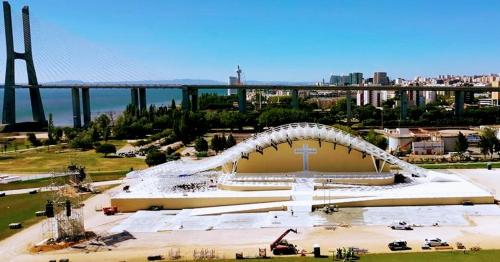 a large building under construction with a bridge in the background at Comfort Relax & Explore Vasco da Gama, Expo Lisbon in Lisbon
