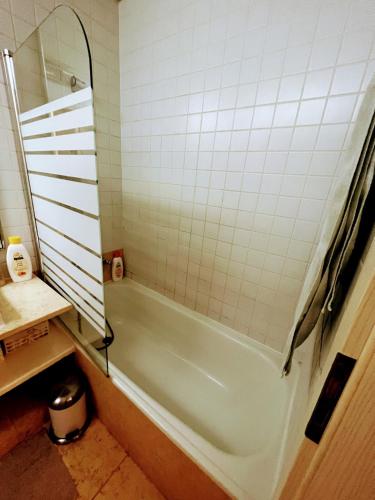 a bathroom with a green tub and white tiles at Comfort Relax & Explore Vasco da Gama, Expo Lisbon in Lisbon