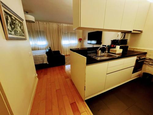a kitchen with white cabinets and a wooden floor at Comfort Relax & Explore Vasco da Gama, Expo Lisbon in Lisbon