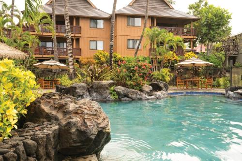 a pool at a resort with chairs and umbrellas at Wyndham Kona Hawaiian 2BR Apartment with Resort Access in Kailua-Kona