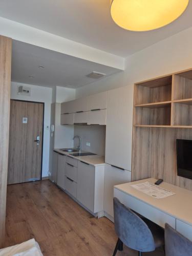a kitchen with white cabinets and a table and a sink at Warsoliv double in Warsaw