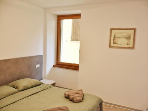 a bedroom with a bed and a window at Appartamento Casaliva in Pieve Di Ledro