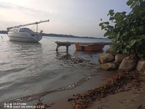 a boat is docked at a dock in the water at Apartament u Romana, in Tałty