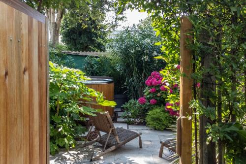 a garden with a chair and some flowers at Escale Rochelaise, chambre avec access spa et sauna in La Rochelle