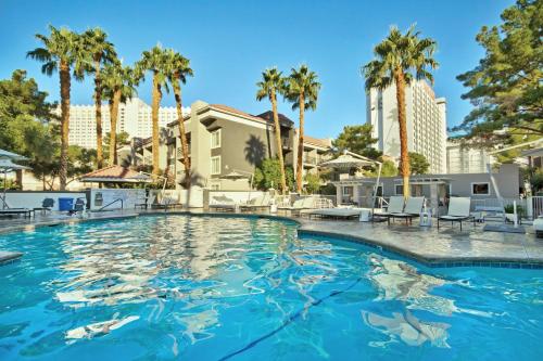 a swimming pool with palm trees and buildings at Wyndham Desert Rose Resort 2BR Apartment with Resort Access in Las Vegas