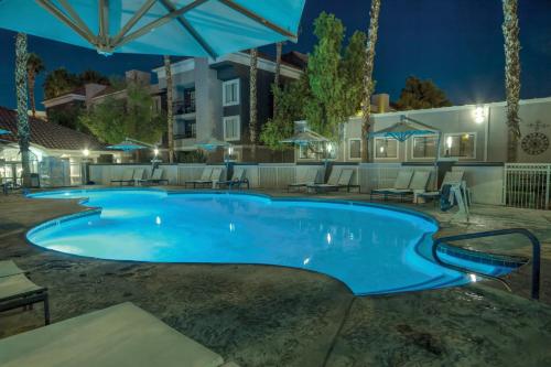 a pool at night with chairs and umbrellas at Wyndham Desert Rose Resort 2BR Apartment with Resort Access in Las Vegas